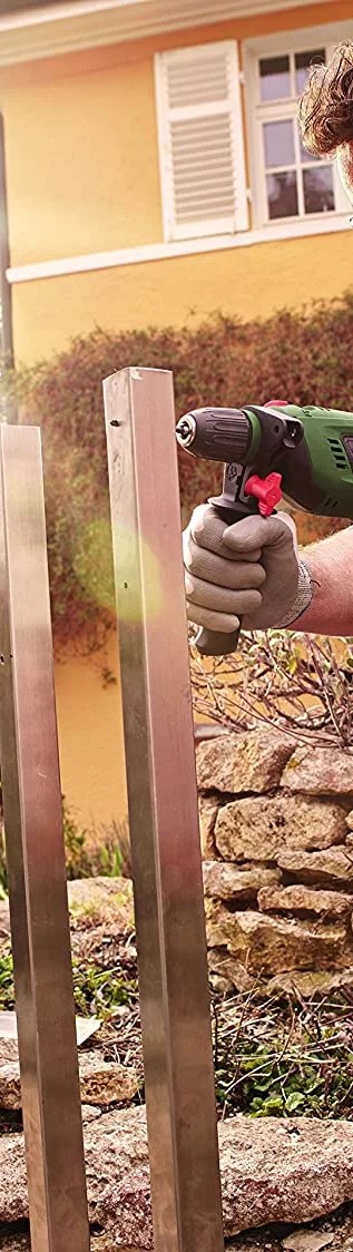 hammer drill being used on a fence post