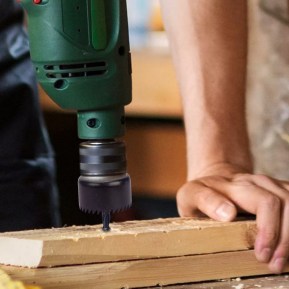 man using a drill with a hole saw attached